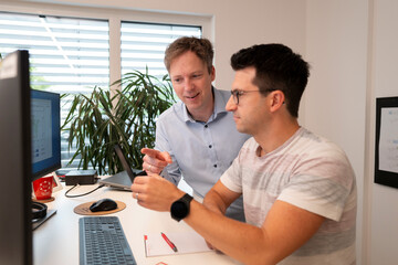 Geschäftsführer erklärt Mitarbeiter etwas